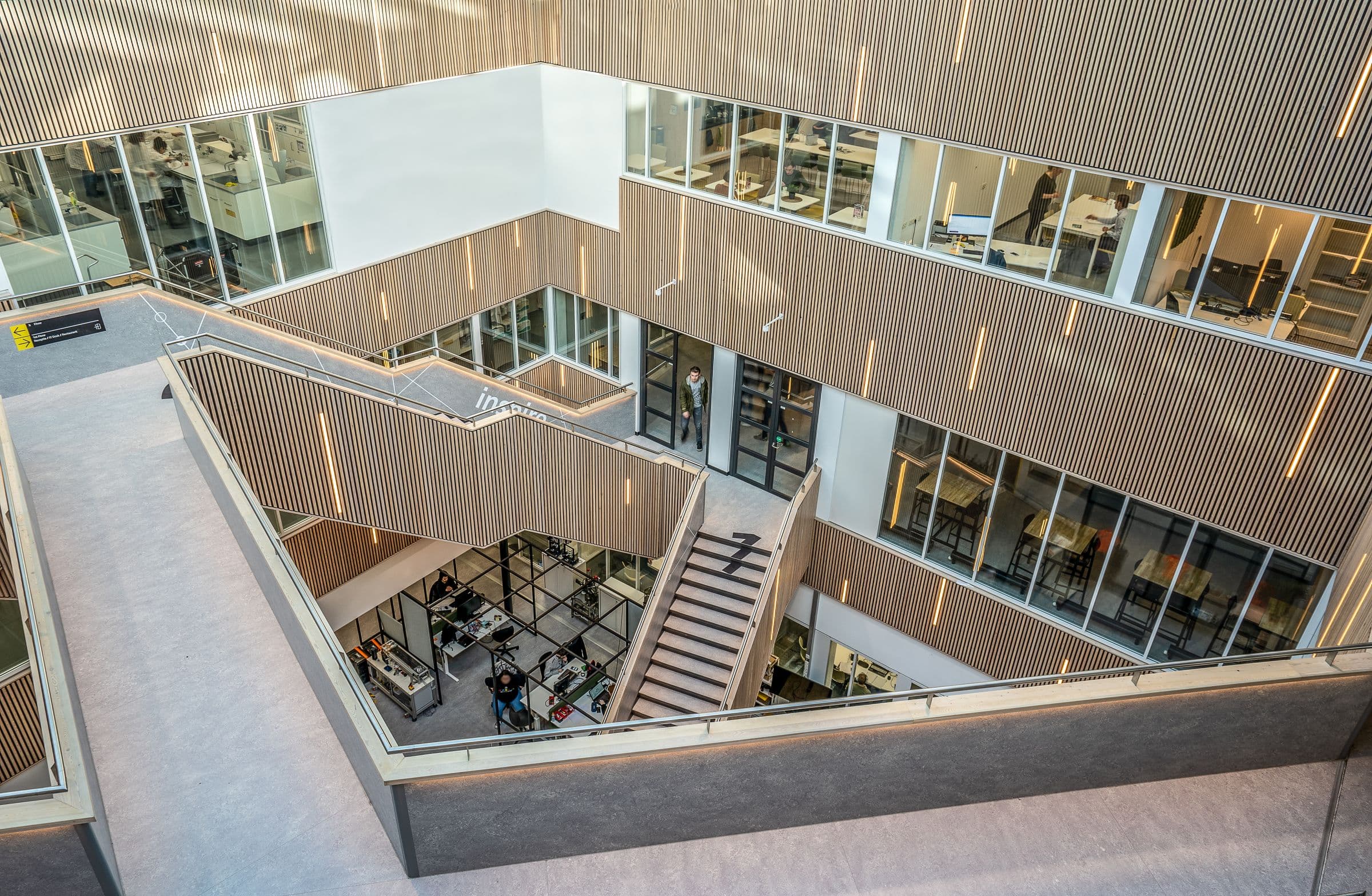 An open timber-lined atrium with stepped workspaces on every level.