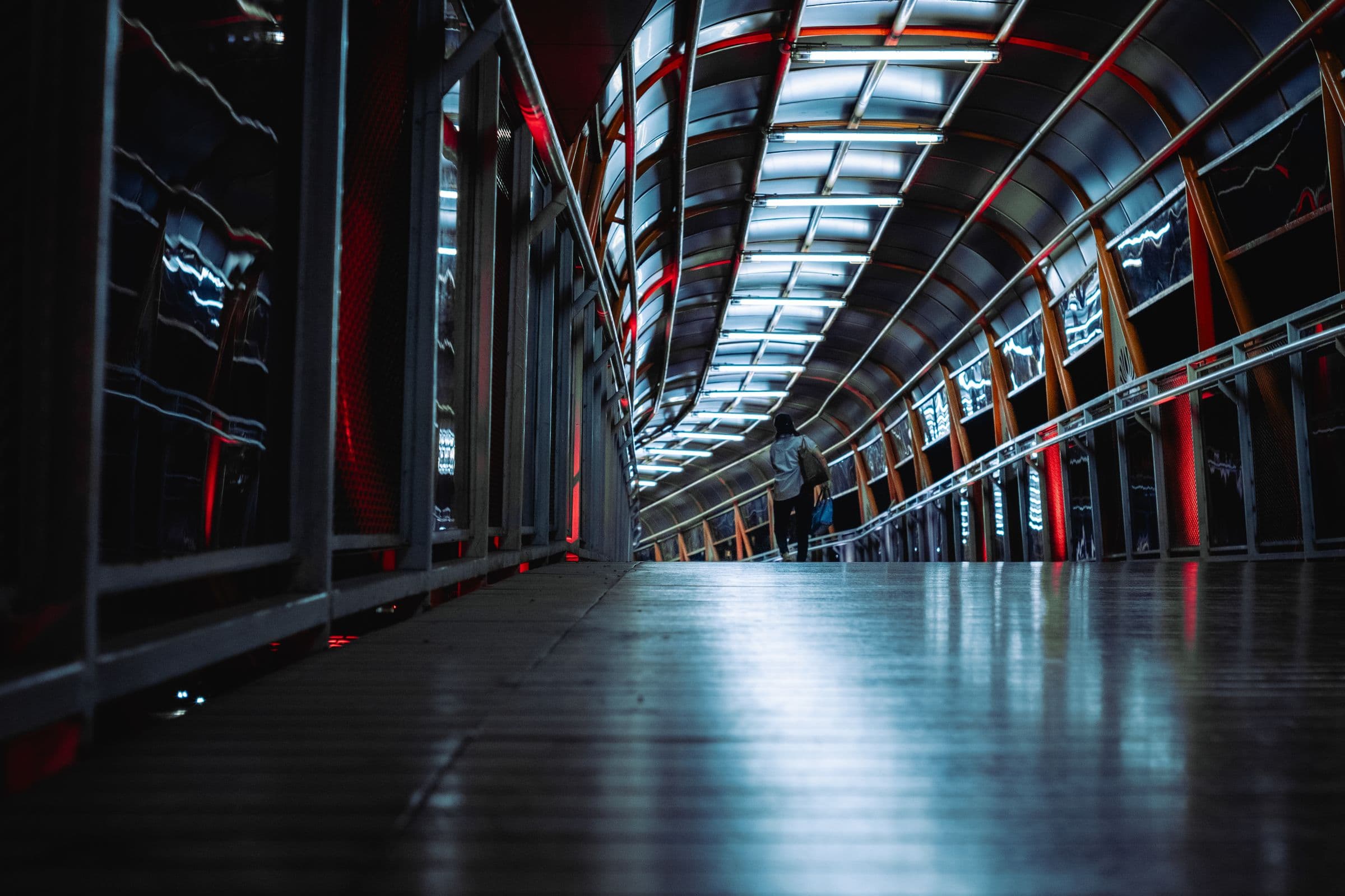A long lit walkway whose ribbed ceiling curves away into the distance.